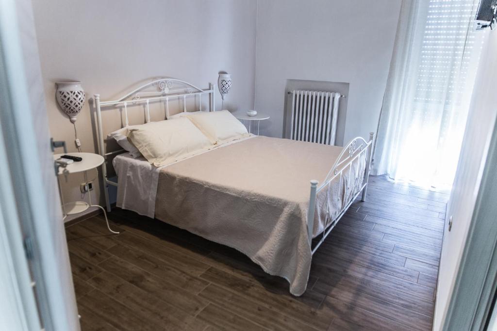 バーリにあるB&B Amelìのウッドフロアのベッドルーム1室(白いベッド1台付)