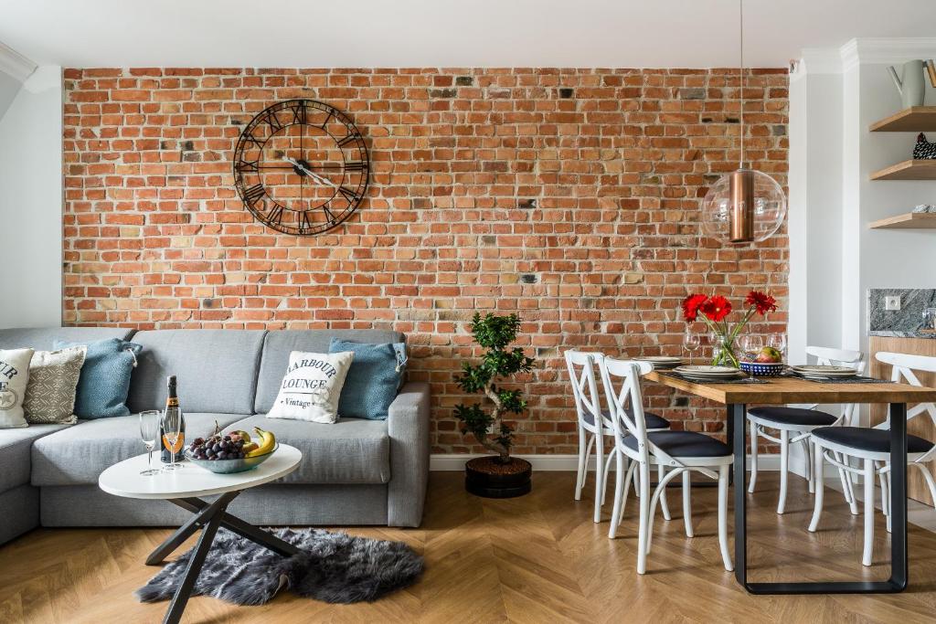 a living room with a couch and a brick wall at Parkowa in Sopot