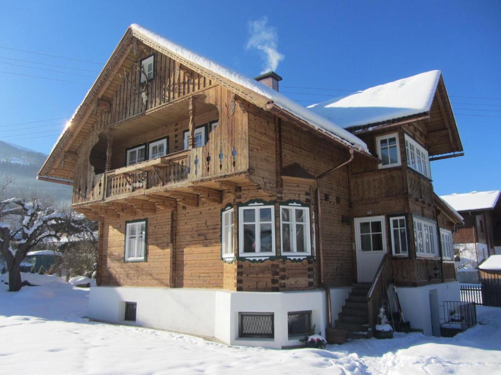une maison en bois avec de la neige au sol dans l'établissement Chalet "Hoamatl", à Haus im Ennstal