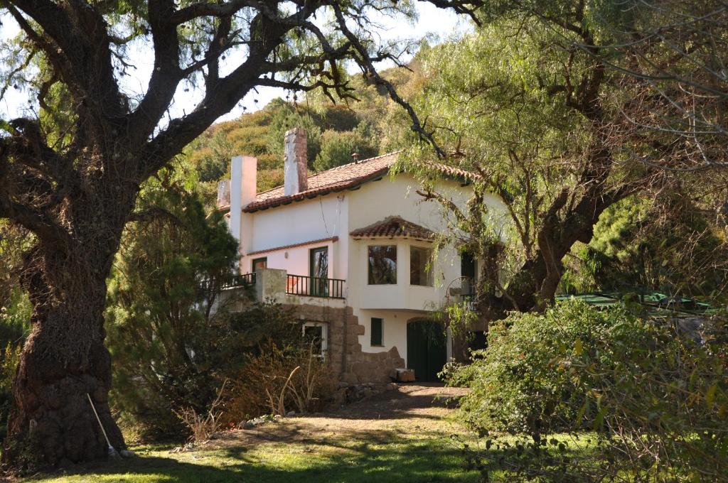 una casa blanca en medio de algunos árboles en Evergreen en La Cumbre