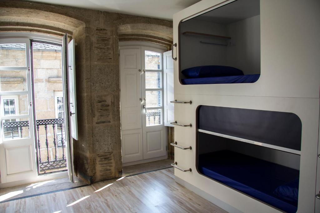 a room with a flat screen tv and a window at Hostel Cross in Lugo