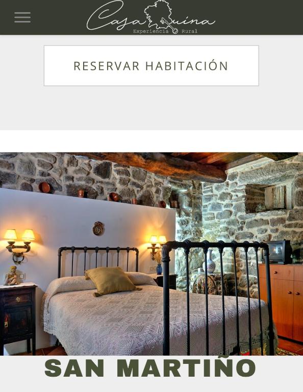 a bedroom with a bed and a stone wall at Casaquina in La Mezquita