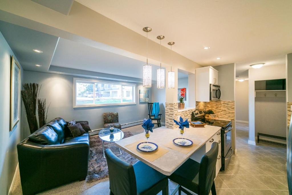 a kitchen and living room with a table and a couch at McKinnon Pointe #102 in Edmonton