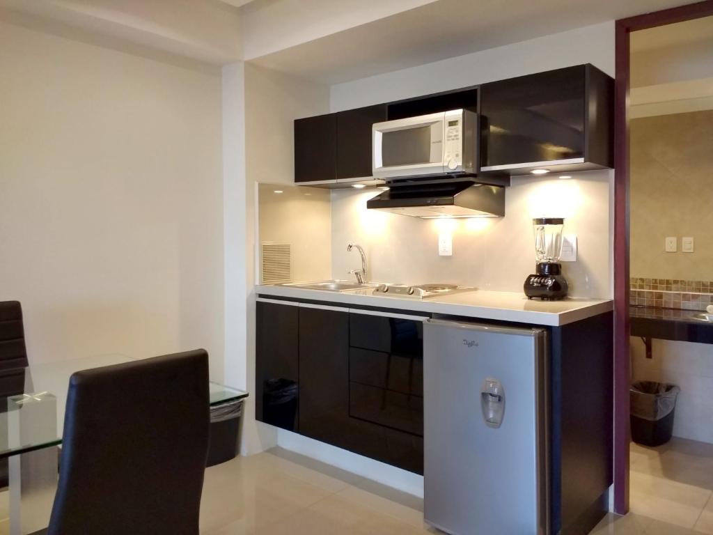 A compact suite kitchen includes a sink, microwave, cooktop, coffee maker, and refrigerator.