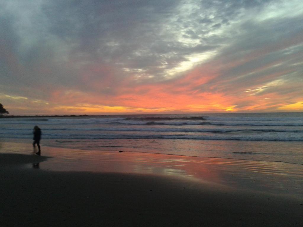 a person walking on the beach at sunset at Depto Maitencillo frente al Mar - Costamai in Maitencillo