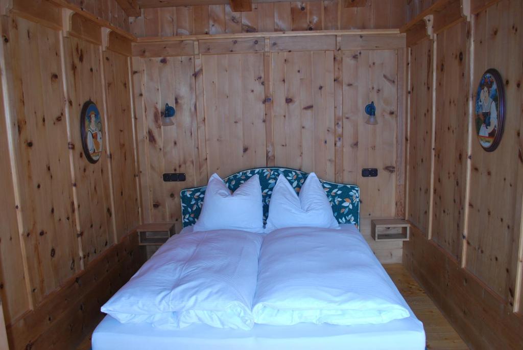 1 dormitorio con 1 cama con paredes de madera en Appartement Seebacher, en Hochfilzen