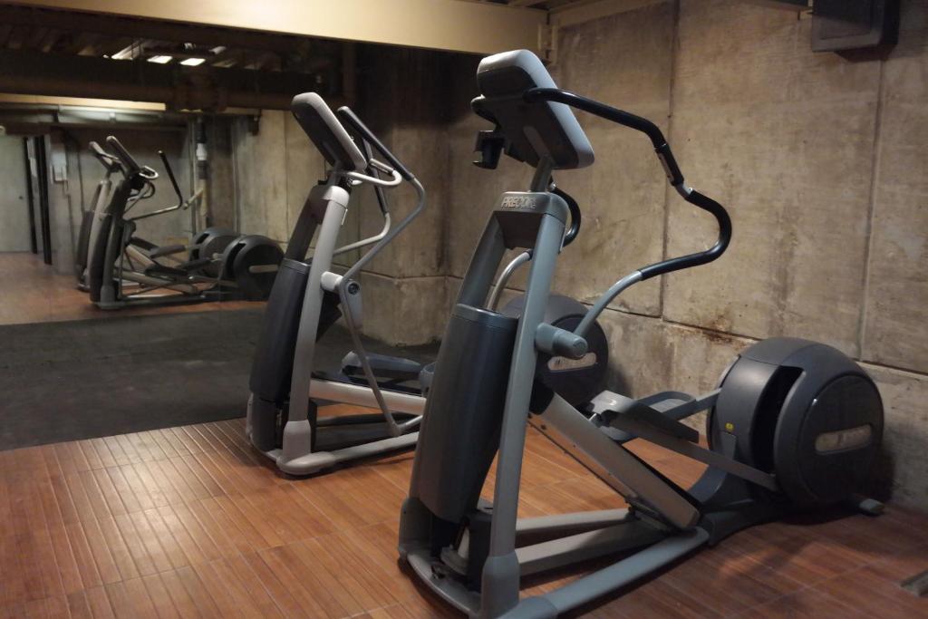 The fitness room has cardio equipment on a wood-look floor.