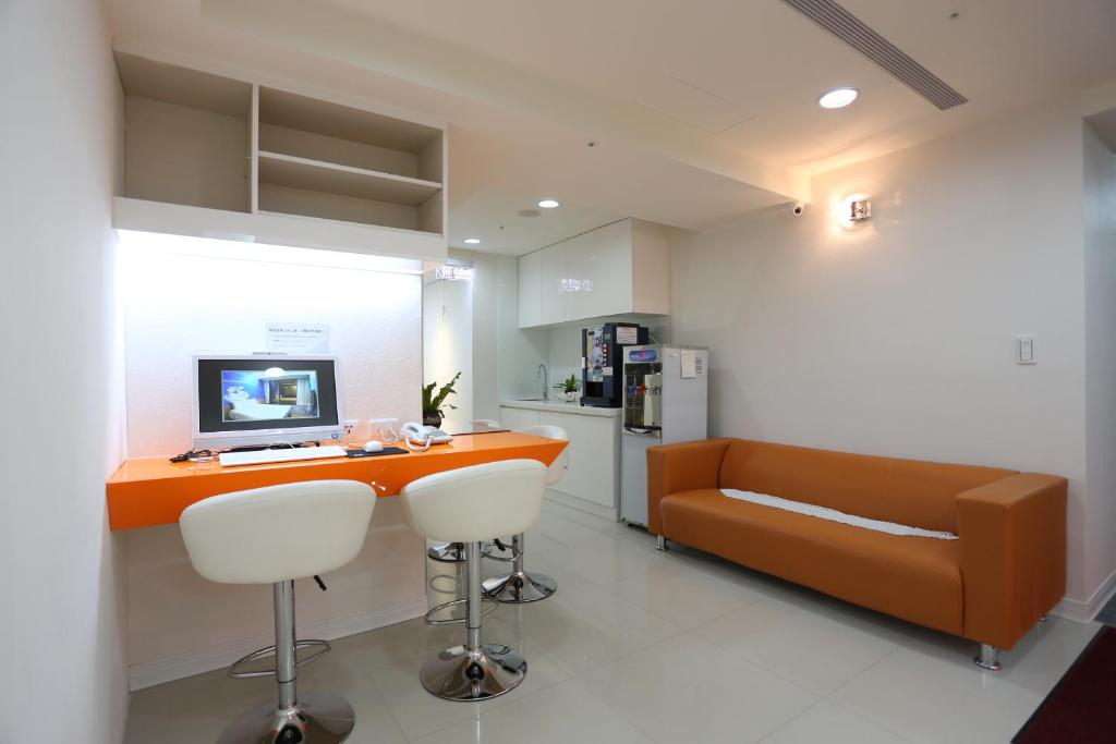 an office with a desk and a couch and a computer at Morwing Hotel Fuzhong in Taipei