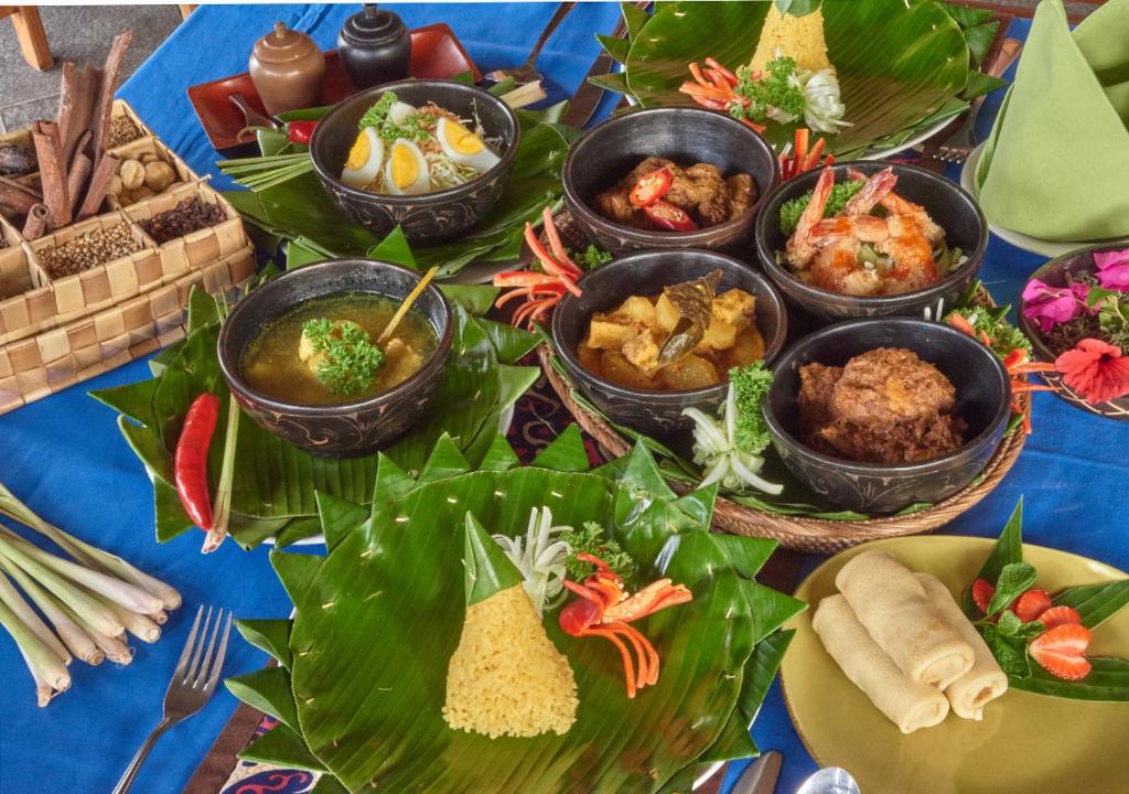a table topped with different types of food on leaves at Cocotinos Sekotong Lombok in Sekotong