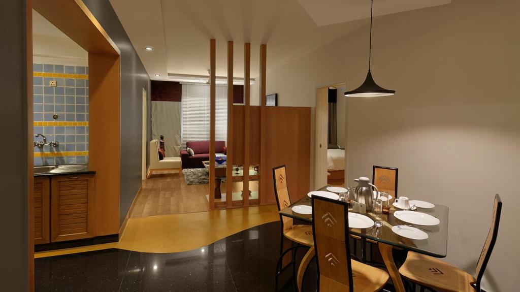 a dining room and kitchen with a table and chairs at Melange Luxury Serviced Apartments in Bangalore