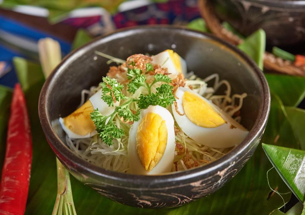 a bowl of food with eggs and noodles at Cocotinos Sekotong Lombok in Sekotong
