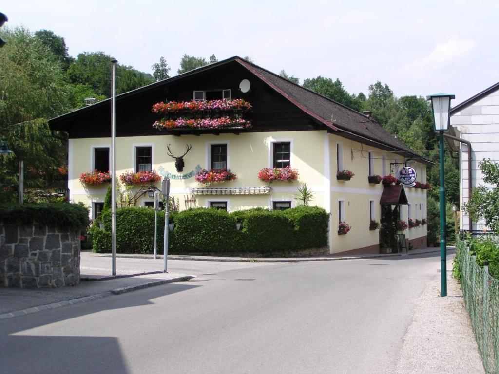 a white house with flower boxes on the side of it at Pension Landhaus Ingrid B&B in Loich