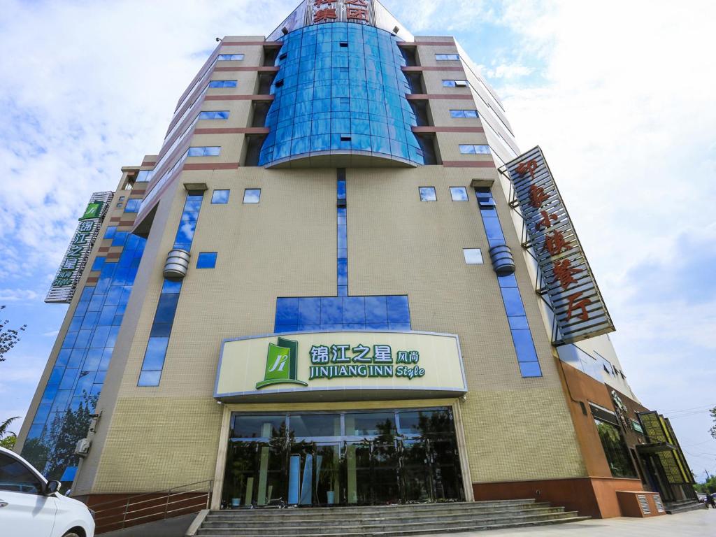 un bâtiment avec une fenêtre bleue au-dessus dans l'établissement Jinjiang Inn Select Jinzhong Qixing Plaza, à Jingcheng