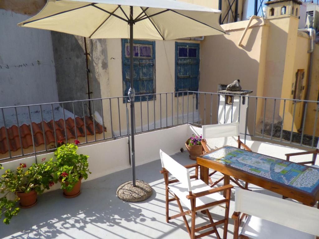 un patio con mesa, sillas y sombrilla en Casa Topane, en La Canea