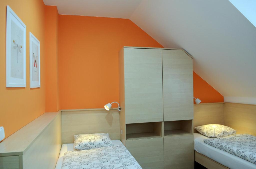 a small attic bedroom with an orange wall at Restaurace Obůrka in Blansko