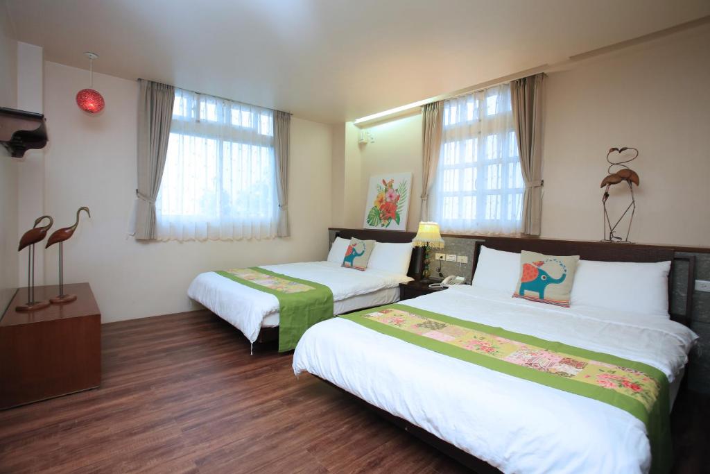 a hotel room with two beds and two windows at Yilan Ya Lu Homestay in Datong