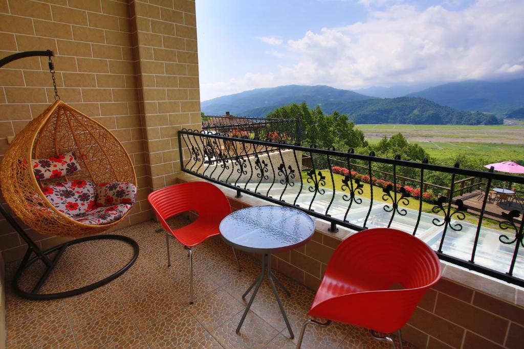 a balcony with red chairs and a window with a view at Yilan Ya Lu Homestay in Datong