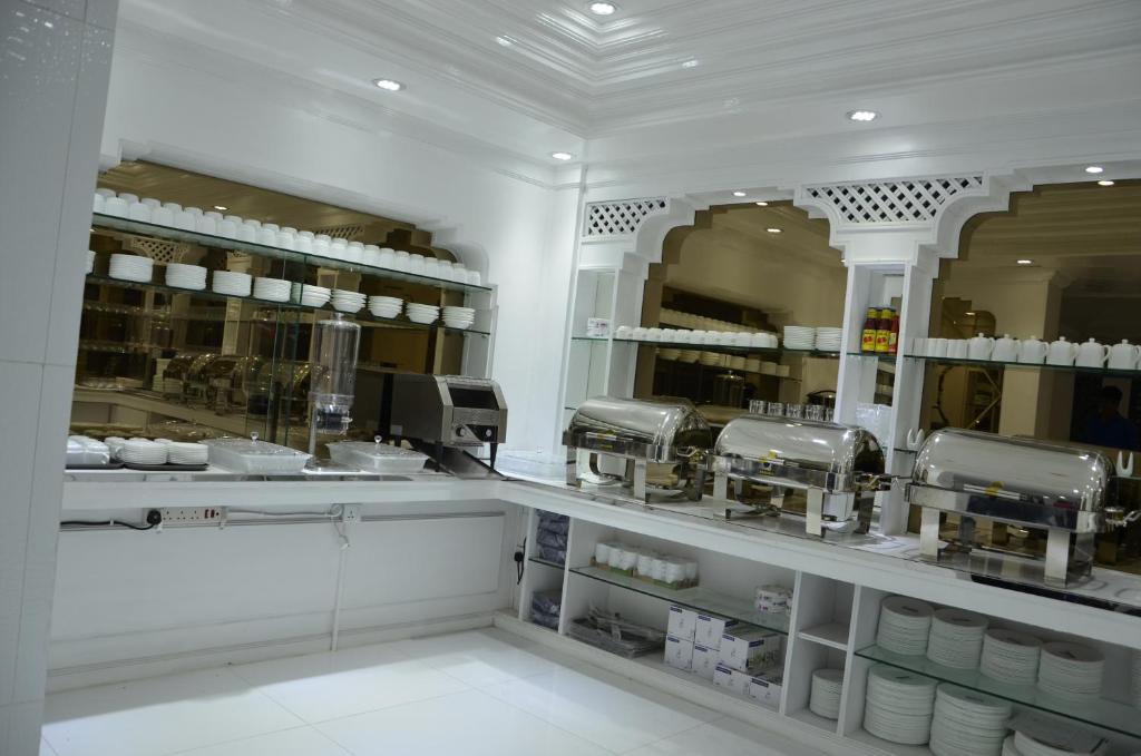 a kitchen with a counter with dishes and coffee machines at White Fort Hotel in Dubai