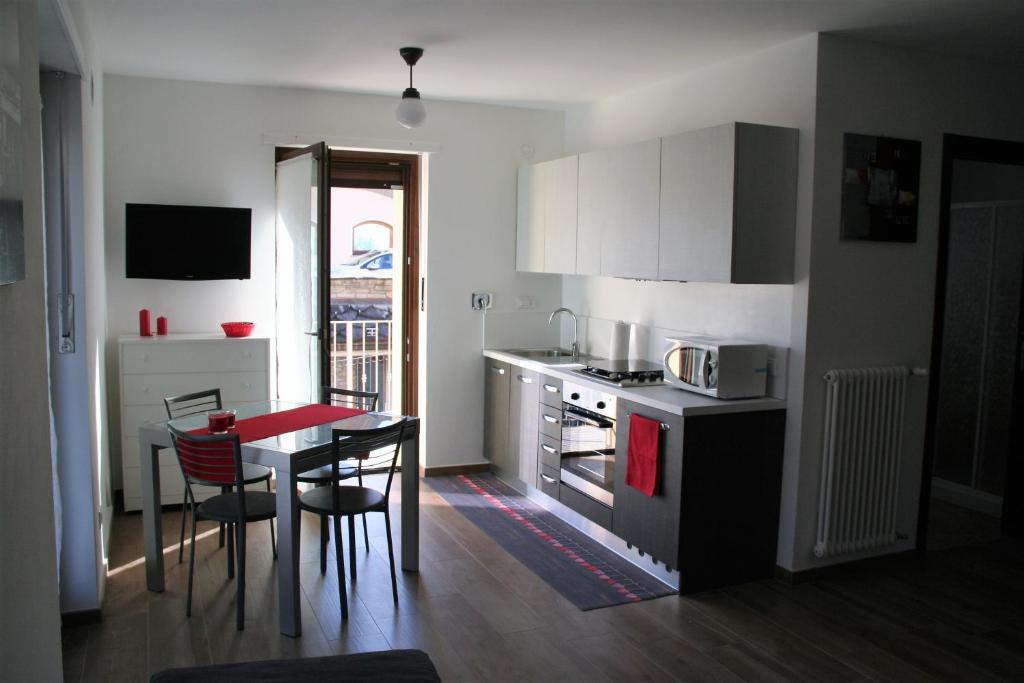 une petite cuisine avec une table, une table et des chaises dans l'établissement Appartamenti Morena CIR 0043-CIR 0044, à Aoste