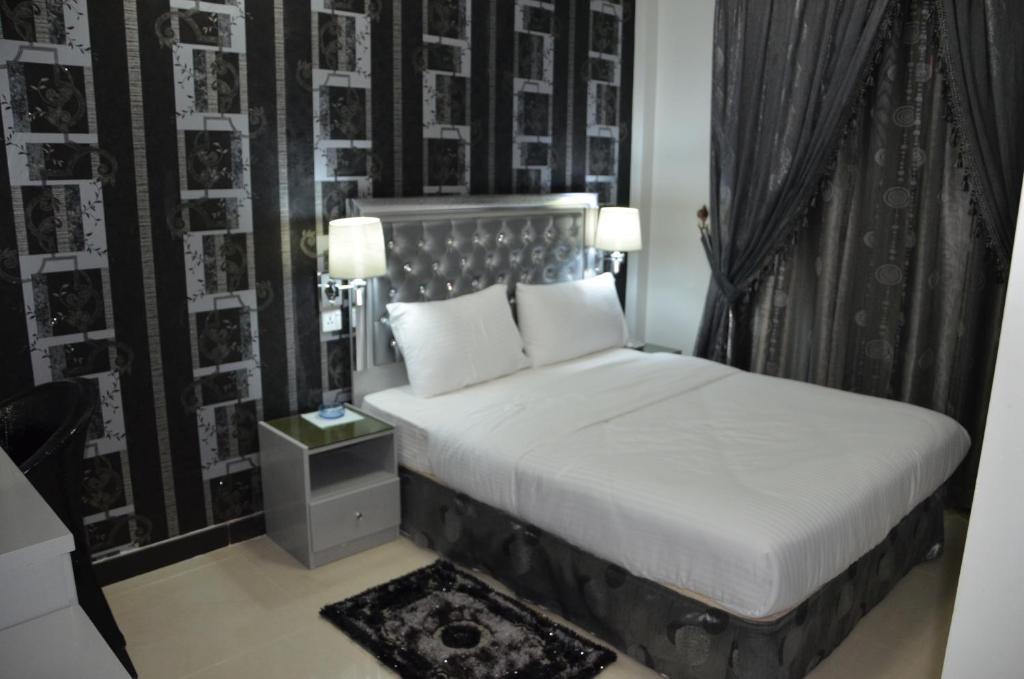 a bedroom with a bed with a black and white wall at White Fort Hotel in Dubai