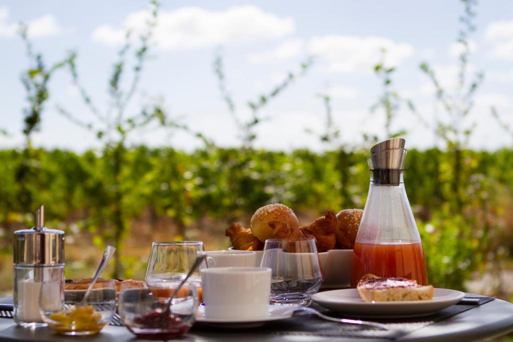 un tavolo con un piatto di cibo e una bottiglia di salsa di Domaine de la Soucherie - Chambres d'hôtes a Beaulieu-sur-Layon