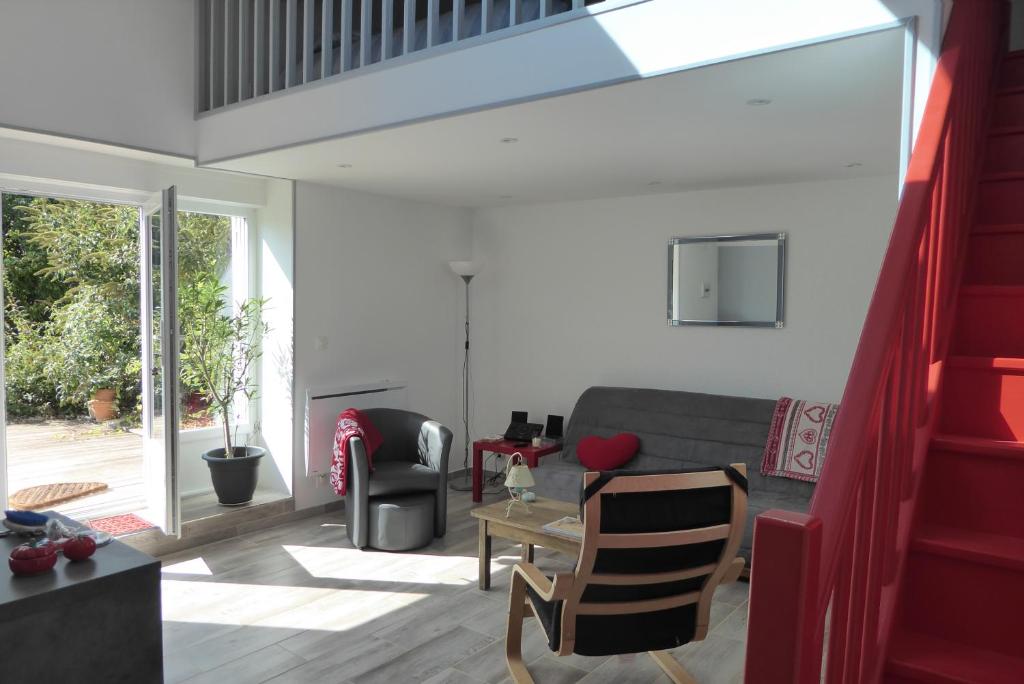 a living room with a couch and a table at Dans un jardin in Apremont-la-Forêt