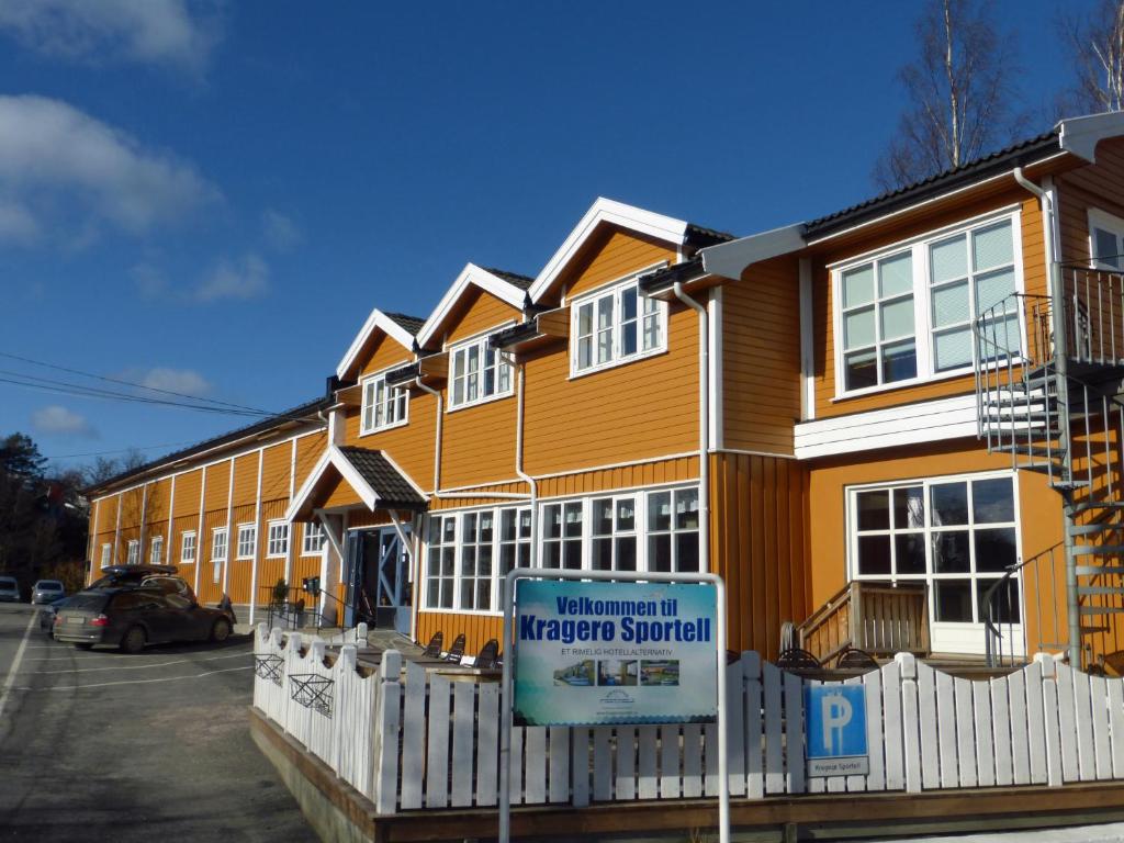 une maison avec un panneau devant elle dans l'établissement Kragerø Sportell & Apartments, à Kragerø