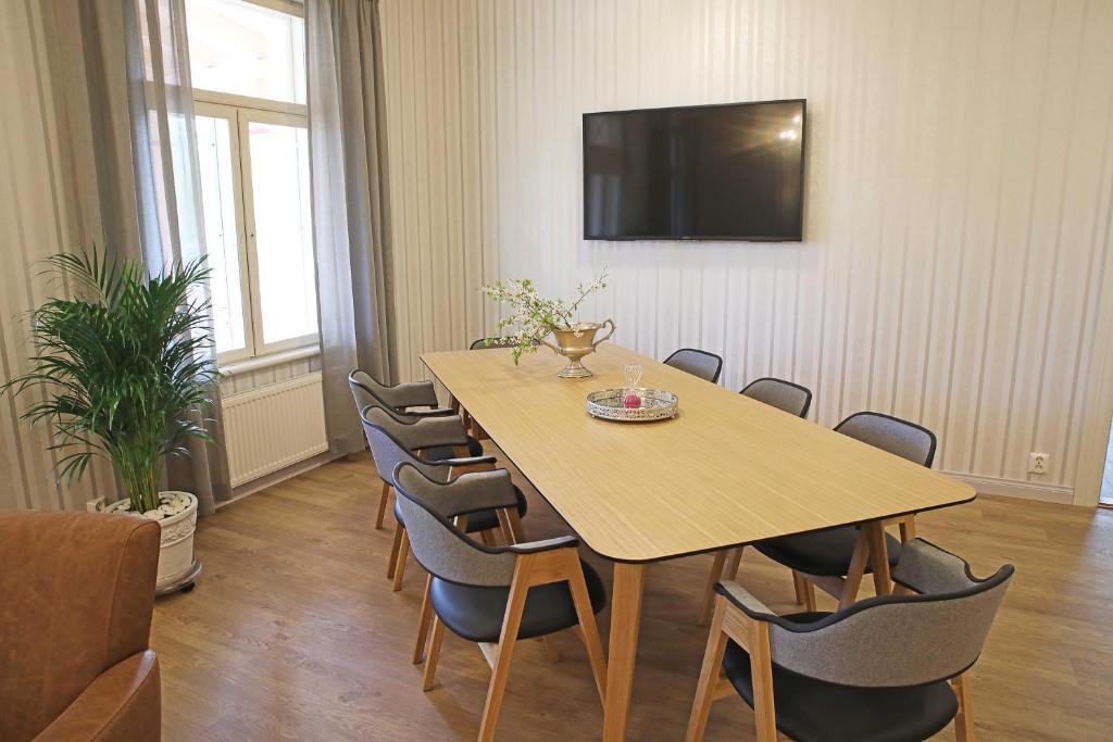 a conference room with a wooden table and chairs at Savonlinnan Kansanopisto - Wanha Pappila in Savonlinna