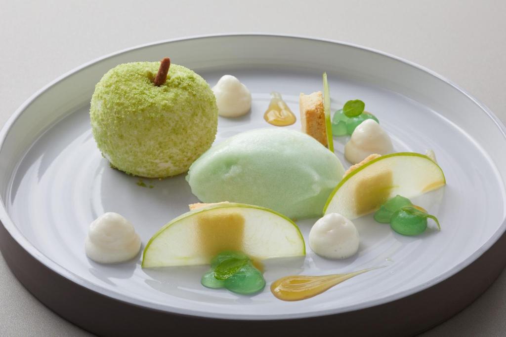 a white plate with an apple and other food on it at Strandhotel Fontana in Timmendorfer Strand