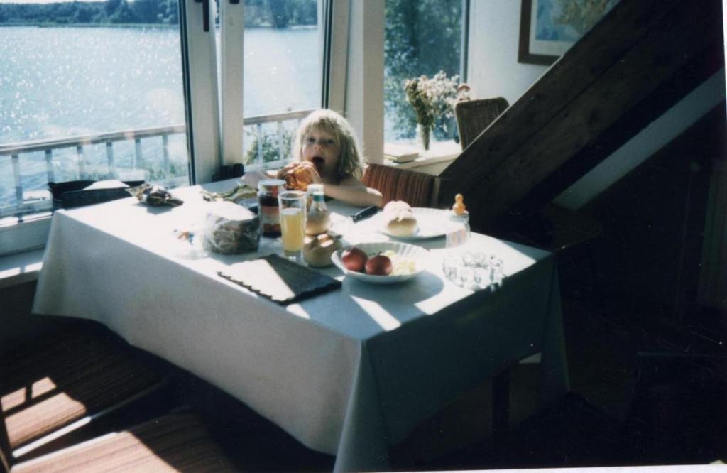 Zarrentin的住宿－Schaalseeblick，坐在餐桌上吃一盘食物的孩子