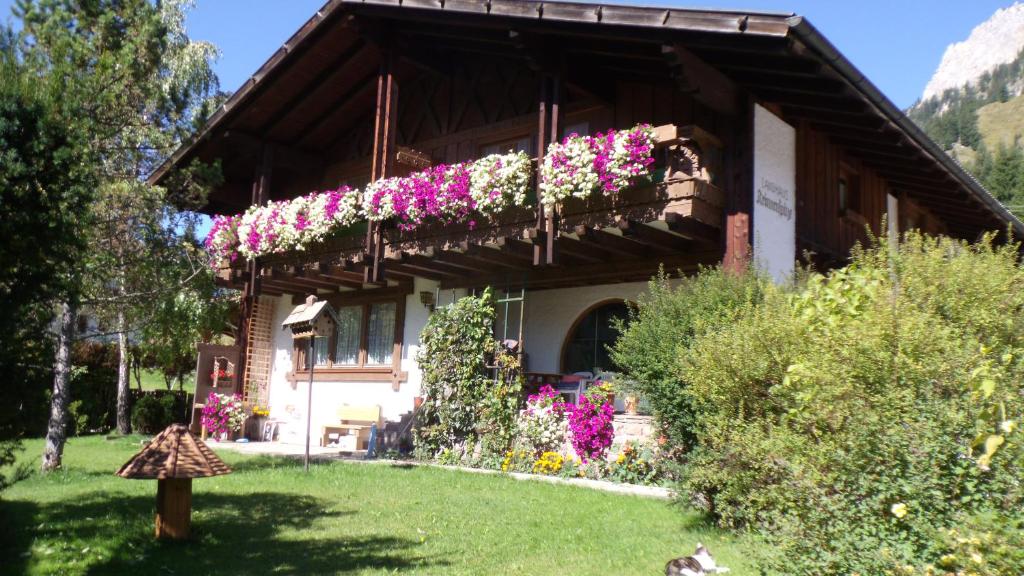 uma casa com flores ao lado dela em Landhaus Krinnenspitze em Nesselwängle