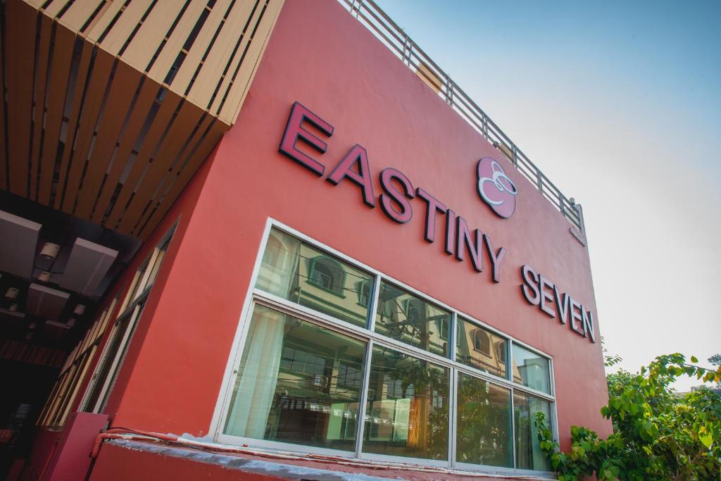 a red building with a sign on the side of it at Eastiny Seven Hotel in Pattaya
