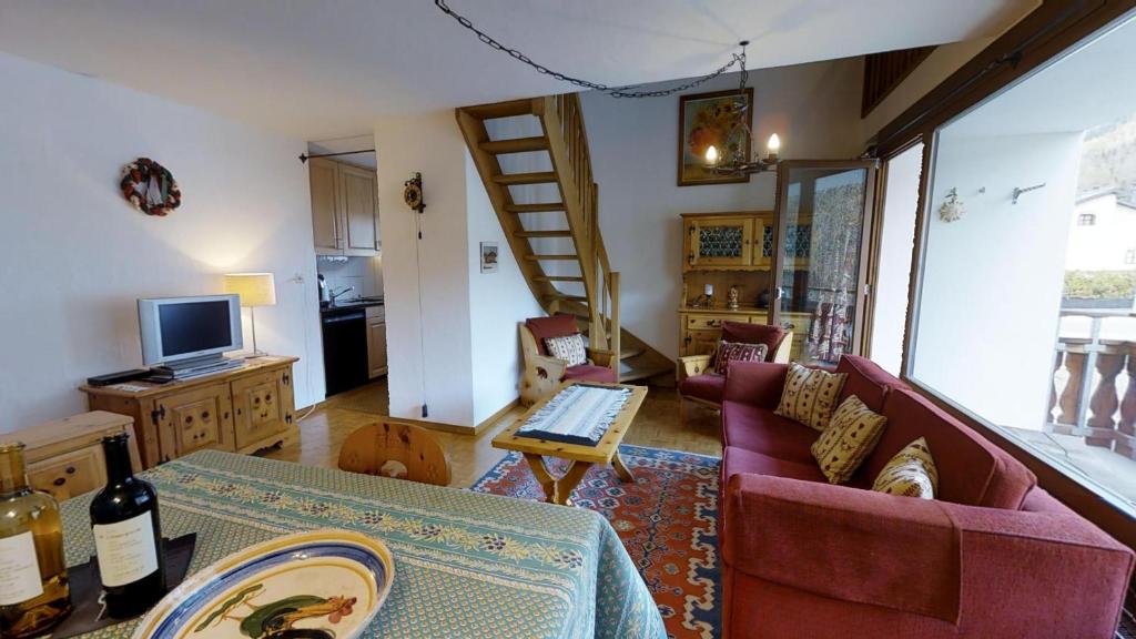 ein Wohnzimmer mit einem Sofa und einem Tisch in der Unterkunft Sur Ovas 8 in La Punt-Chamues-ch