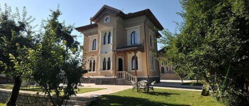 una casa grande con sillas delante en Albergo Villino Quintiliani, en Pescasseroli