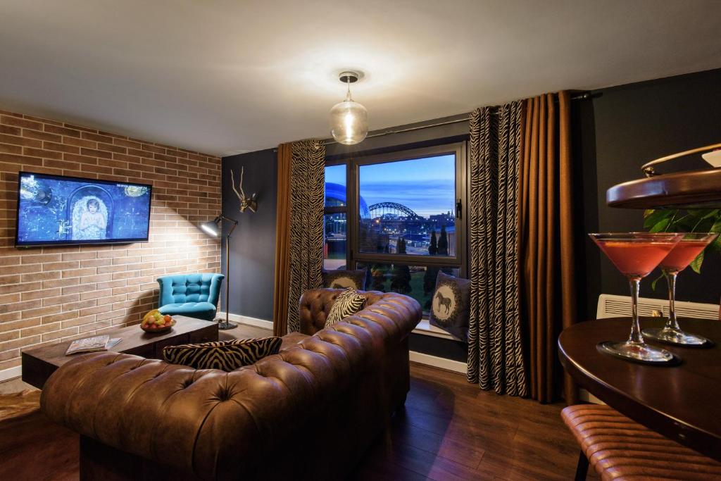 a living room with a leather couch and a large window at 134 Baltic Quay in Newcastle upon Tyne