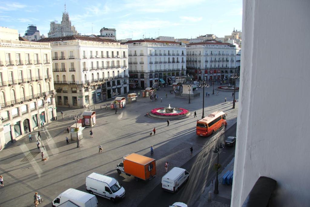 Vistas a una concurrida calle de la ciudad con coches y autobuses en Apartamentos Sol Mayor, en Madrid
