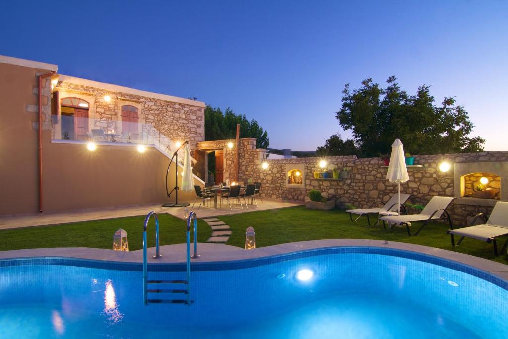 un patio trasero con piscina y una casa en Blue Paradise, en Margarítai
