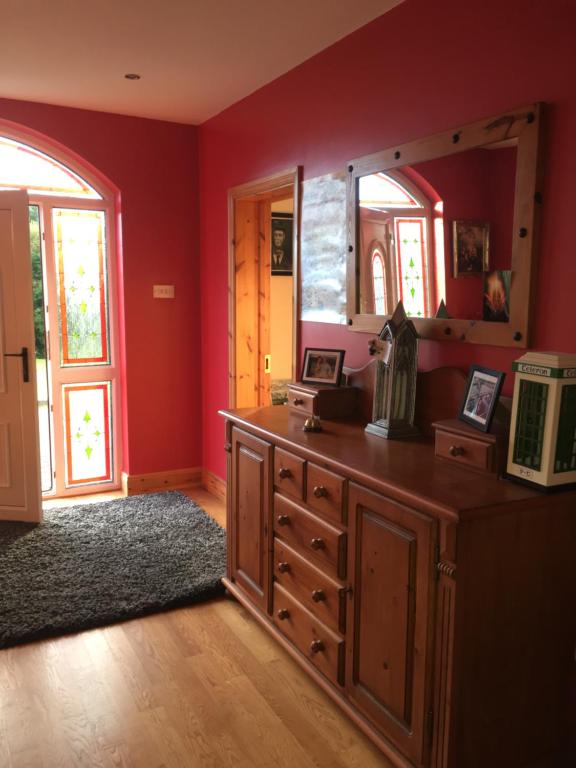 a room with a wooden dresser and a mirror at Carrick House B&B in Killybegs