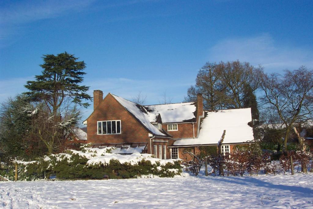 Una gran casa de ladrillo con nieve. en Mayertorne Cottage en Aylesbury
