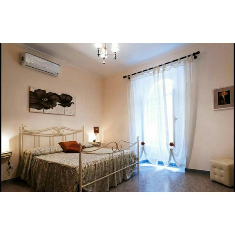 una camera con un letto e una grande finestra di Domus Ines Roma San pietro a Roma