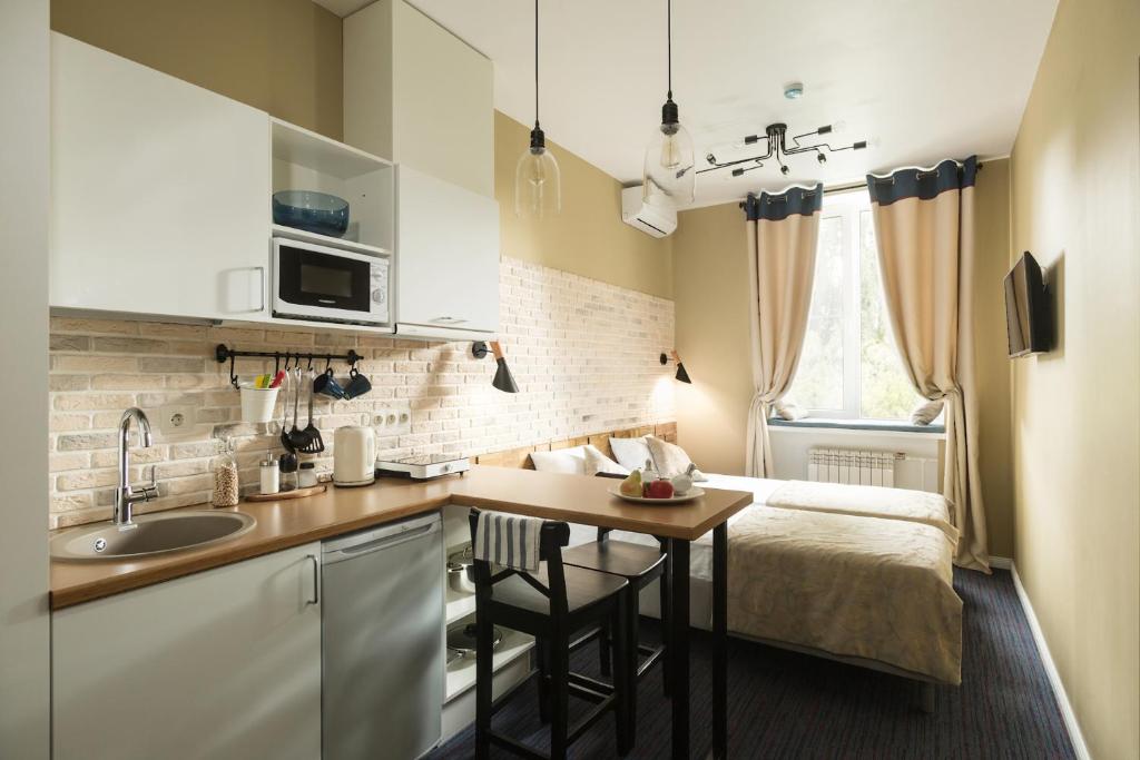 a small kitchen with a sink and a bed in a room at Hotel Sofia in Velikiy Novgorod