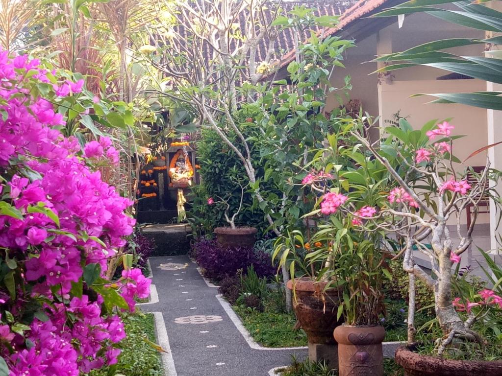 a garden with pink flowers and plants at Krisda Ubud Guest House in Ubud