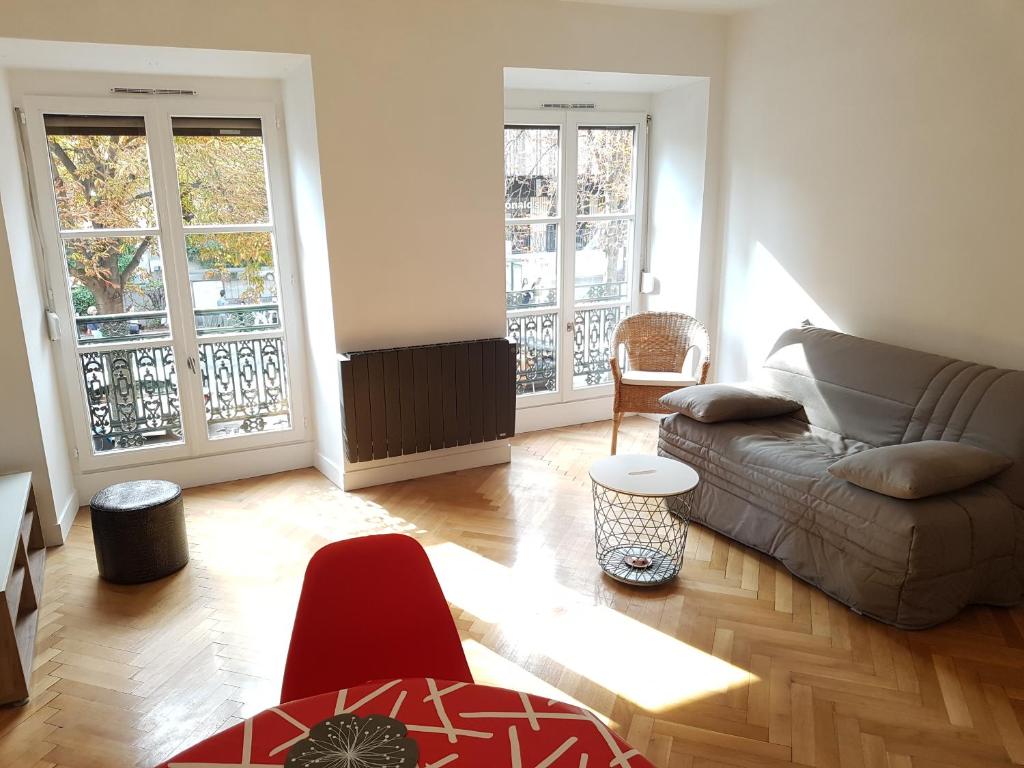 a living room with a couch and a table at L'EUROSEBASTOPOL in Strasbourg