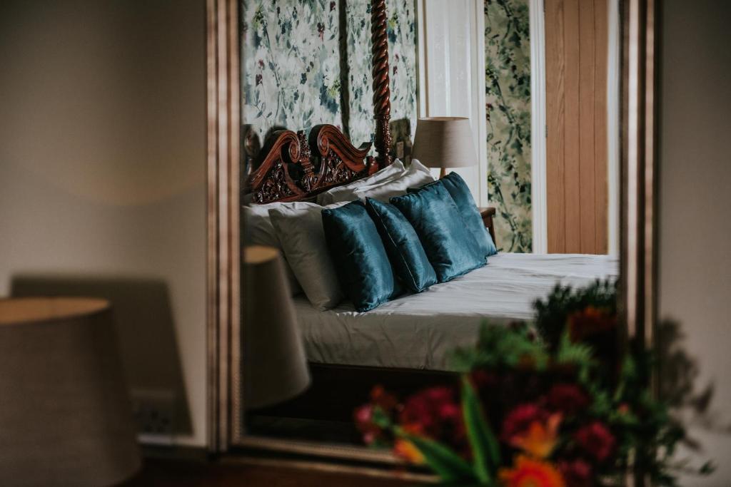 a mirror reflection of a bed in a bedroom at Healing Manor Hotel in Grimsby