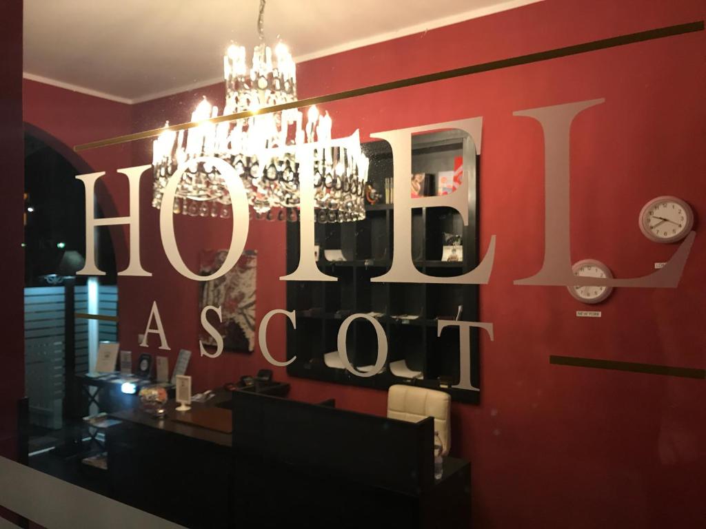 a chandelier hanging over a store window with the words hog ashout at Hotel Ascot in Caianello