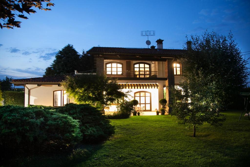 una casa grande con sus luces encendidas en el patio en Le Peonie en Peveragno
