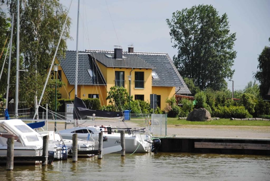 un barco atracado en un muelle frente a una casa en Ferienhaus am Saaler Bodden, en Neuendorf