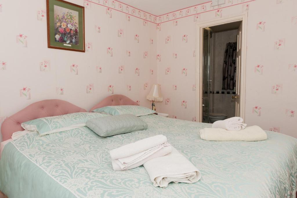a bedroom with a bed with towels on it at Birtley House Guest House B&B in Telford