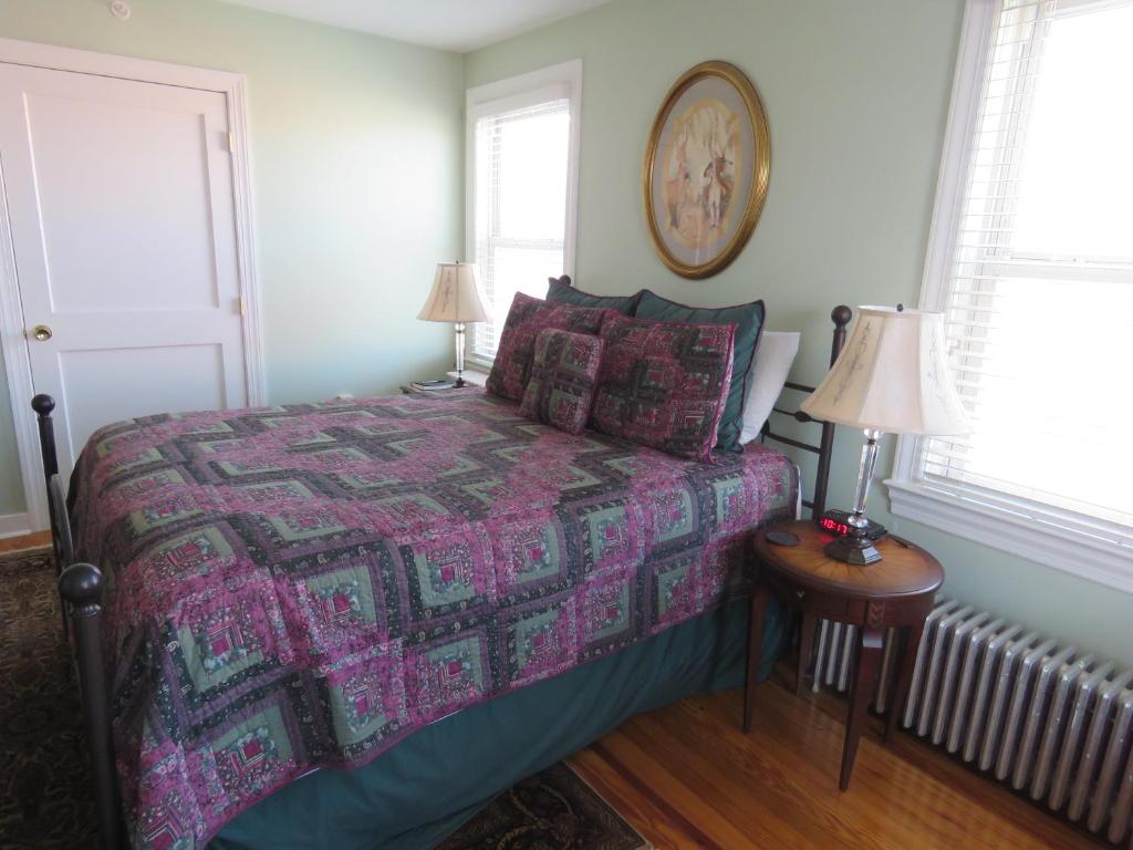 1 dormitorio con 1 cama con colcha púrpura y 2 lámparas en The Swope Manor Bed & Breakfast, en Gettysburg