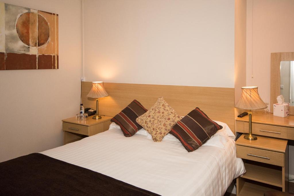 1 dormitorio con 1 cama blanca y 2 mesitas de noche en Byards Leap Lodge en Cranwell